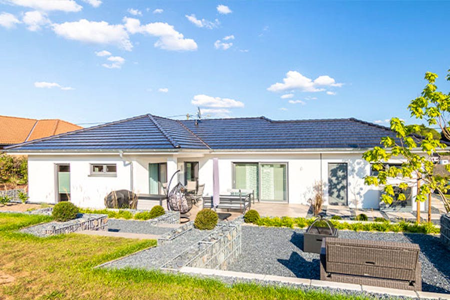 Der Winkelbungalow kombiniert ebenerdigen Wohnkomfort mit einer charakteristischen Architektur. Das Walmdach verbindet das Haus und die integrierte Garage zu einer harmonischen Einheit, während die Winkelform einen geschützten Terrassenbereich schafft. Der Bungalow wurde mit den Deutschen Traumhauspreis in Silber ausgezeichnet.